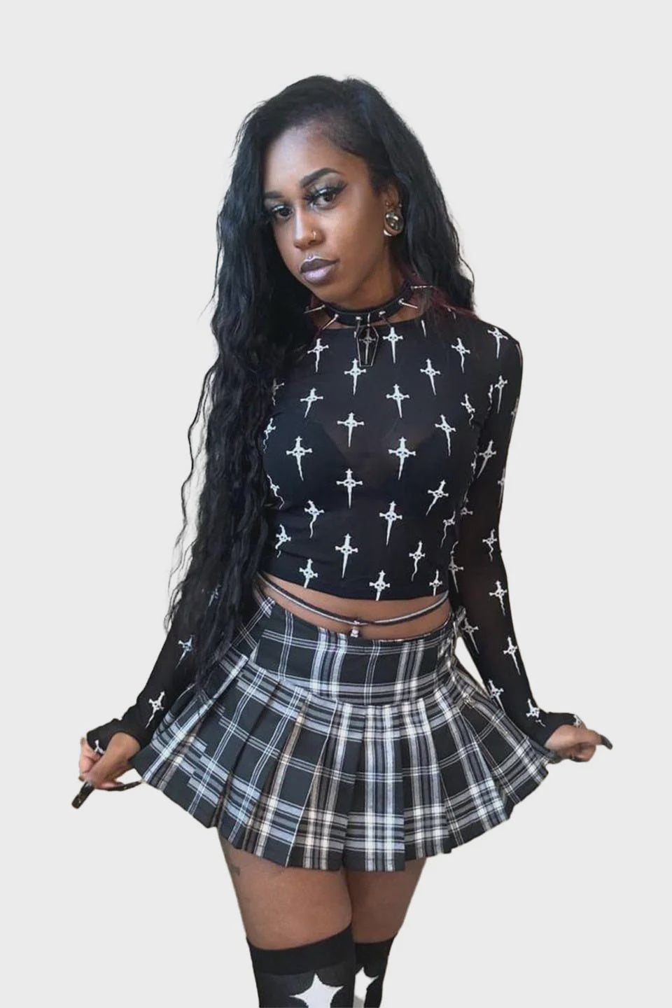 Model wearing a black dagger-print long-sleeve mesh top and plaid skirt.
