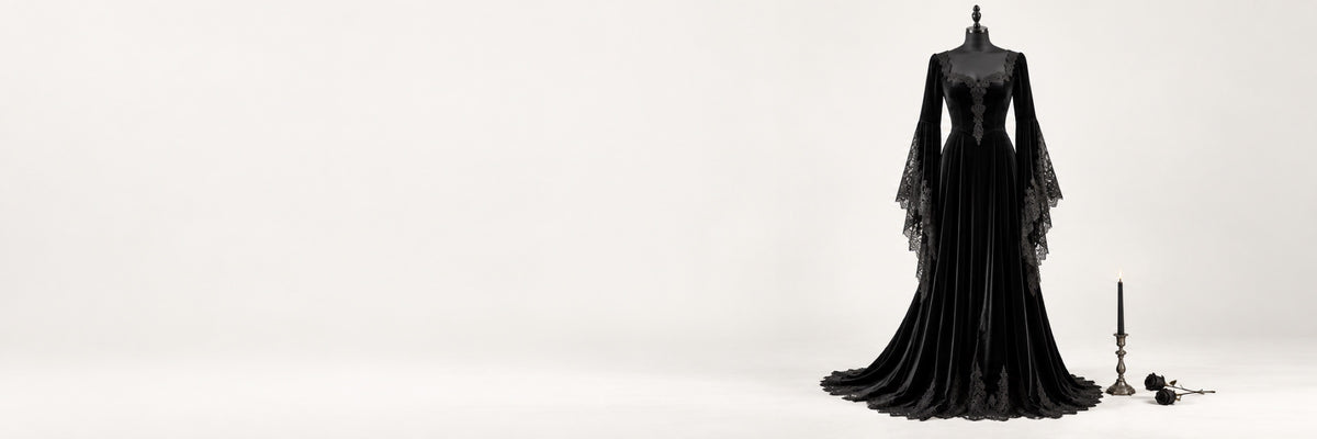 Black velvet gothic gown with lace bell sleeves on a dress form against a white studio backdrop
